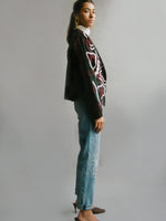 Fanfare Label sustainable women’s clothing brand UK. Our upcycled jeans are high-waisted, blue denim and made from recycled denim. We decorate every jean with a white embroidered thread in a face design.