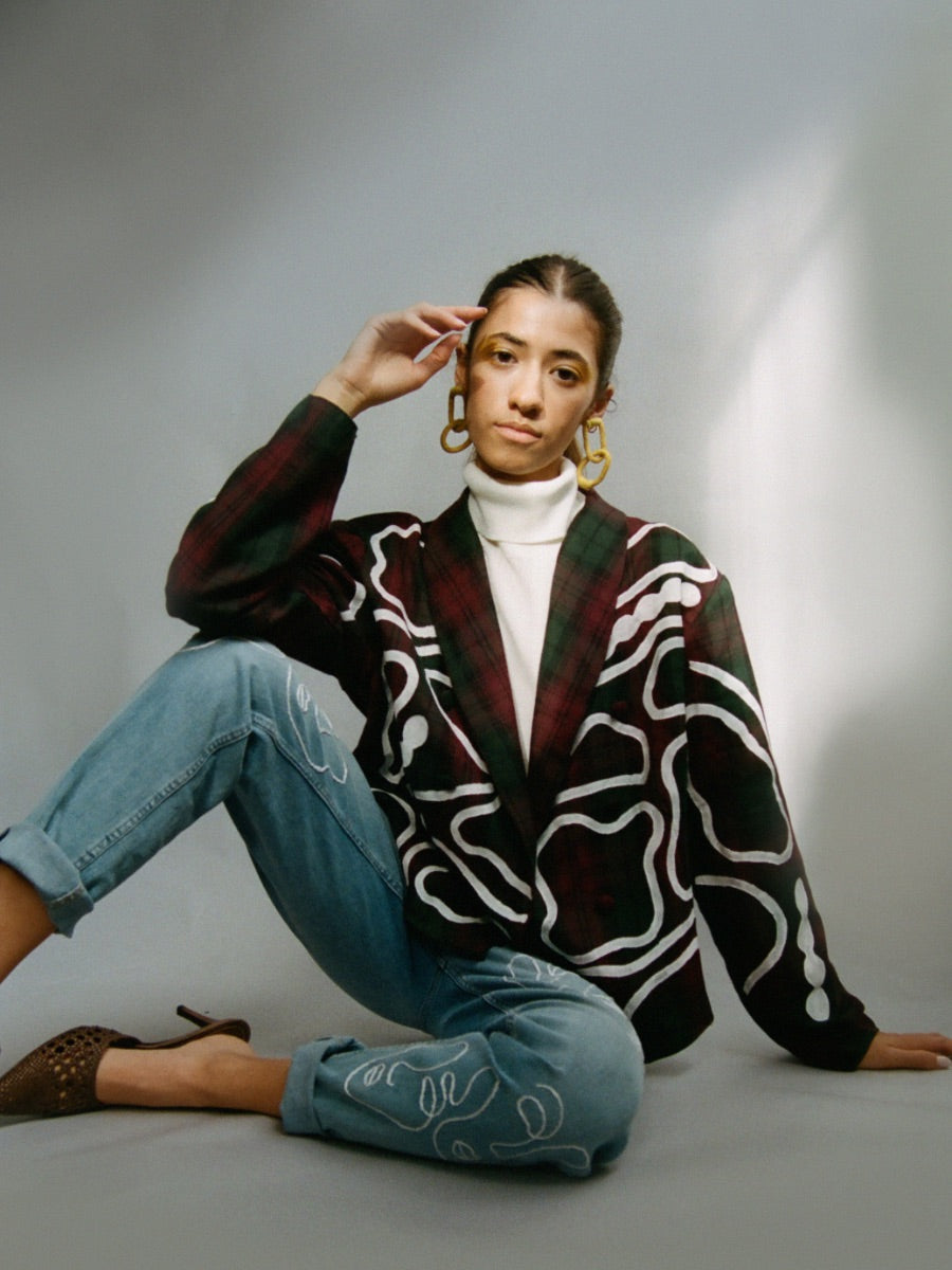 Fanfare Label sustainable women’s clothing brand UK. Our upcycled jeans are high-waisted, blue denim and made from recycled denim. We decorate every jean with a white embroidered thread in a face design.