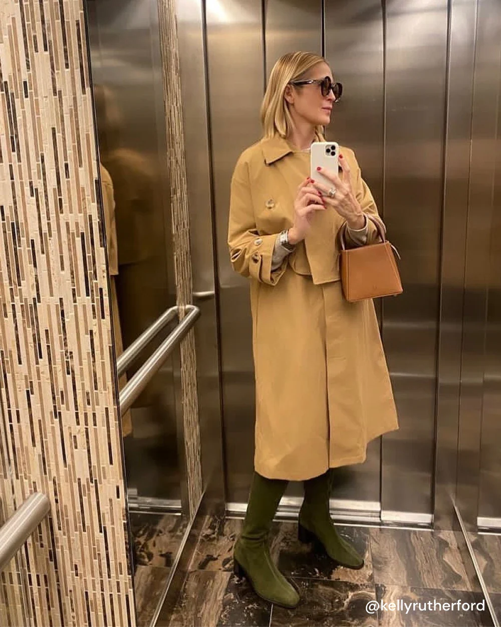 Kelly porte les bottes CRISTOBAL à talon en daim kaki avec un trench camel