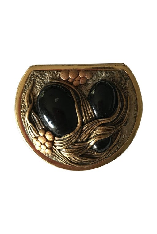 Gold metal brooch with black stones